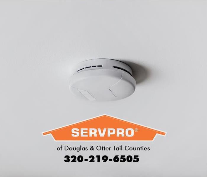 A smoke alarm is mounted on a ceiling.