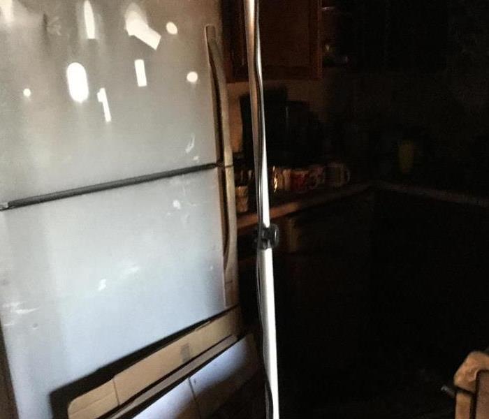 Soot stained fridge in a kitchen. 