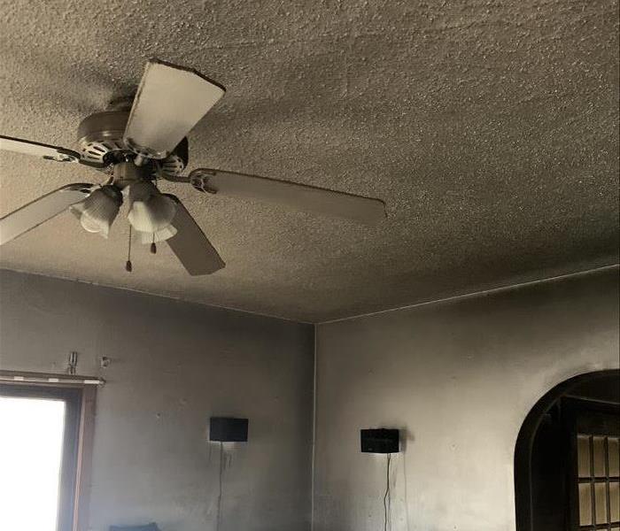 Living room and ceiling covered in dark grey soot. 