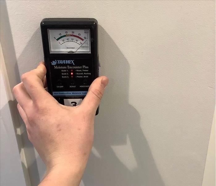Moisture meter up against a wall. 